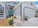 Close-up of home exterior with teal front door, landscaping, and a two-car garage at 142 Ethan Ave, Davenport, FL 33897