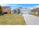Charming single-Gathering home features a teal front door, well-maintained lawn, and an attached two-car garage at 142 Ethan Ave, Davenport, FL 33897