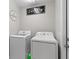 This laundry room features a washer and dryer with white cabinets and a laundry sign at 142 Ethan Ave, Davenport, FL 33897