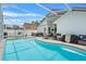 Inviting screened-in pool area with a spa, lounge swing, and ample space for entertaining and relaxation at 142 Ethan Ave, Davenport, FL 33897