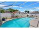 Sparkling in-ground swimming pool with screened enclosure and well-manicured landscaping at 142 Ethan Ave, Davenport, FL 33897