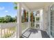 A covered balcony featuring white railing and columns with views of palm trees at 1501 Northern Harrier Way # 202, Reunion, FL 34747