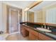 Primary bathroom boasts double sinks, a large mirror, and glass enclosed shower at 1501 Northern Harrier Way # 202, Reunion, FL 34747