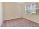 Bedroom with plush carpeting and large window with blinds at 1501 Northern Harrier Way # 202, Reunion, FL 34747