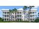 Three-story condo building with balconies and palm trees at 1501 Northern Harrier Way # 202, Reunion, FL 34747