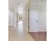 Tiled hallway leading to a carpeted bedroom, with a doorway on the right at 1501 Northern Harrier Way # 202, Reunion, FL 34747