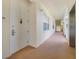 Hallway with white walls and carpet leading to a unit door at 1501 Northern Harrier Way # 202, Reunion, FL 34747