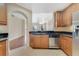 Well-lit kitchen boasts wood cabinets, stainless steel appliances, and dark countertops at 1501 Northern Harrier Way # 202, Reunion, FL 34747