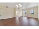 Open living room with hardwood floors, chandelier, and view to patio at 1501 Northern Harrier Way # 202, Reunion, FL 34747