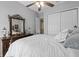 Comfortable bedroom with white comforter, dark wood dresser, and closet at 15037 Cedar Branch Way, Orlando, FL 32824