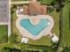 Overhead view of a uniquely shaped community pool with ample seating and umbrellas at 15037 Cedar Branch Way, Orlando, FL 32824