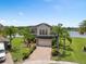 Attractive two-story home boasting a manicured lawn, brick driveway, and lake views at 15037 Cedar Branch Way, Orlando, FL 32824