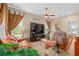 Comfortable living room featuring leather seating, decorative lamps, and large windows with decorative curtains at 15037 Cedar Branch Way, Orlando, FL 32824