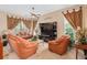 Warm and inviting living room with plush leather seating, a ceiling fan, and ample natural light at 15037 Cedar Branch Way, Orlando, FL 32824