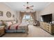 Bright primary bedroom with neutral walls, decorative window treatments, and ceiling fan at 15037 Cedar Branch Way, Orlando, FL 32824