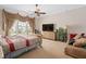Bright primary bedroom featuring neutral walls, ceiling fan, and an upholstered chair at 15037 Cedar Branch Way, Orlando, FL 32824