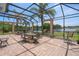 Screened lanai with brick flooring and seating area overlooks a serene lake at 15037 Cedar Branch Way, Orlando, FL 32824