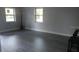 Spacious living area with modern flooring, neutral paint, and natural light from two windows at 1605 N Orange St, Mount Dora, FL 32757