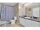 Bright bathroom featuring a granite countertop, white vanity, and a shower with decorative curtain at 1651 Windsor Oak Ct, Kissimmee, FL 34744