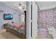 Cozy bedroom leading to an ensuite bathroom, furnished with a tv and comfortable bedding at 1651 Windsor Oak Ct, Kissimmee, FL 34744