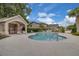 Community pool with lounge chairs, cabana, and lush landscaping on a sunny day at 1651 Windsor Oak Ct, Kissimmee, FL 34744