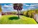 Expansive backyard featuring lush lawn, mature landscaping and screened lanai on a sunny day at 1723 Brassie Ct, Kissimmee, FL 34746
