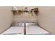 Functional laundry room with washer, dryer, and upper shelf for storage at 1723 Brassie Ct, Kissimmee, FL 34746
