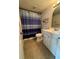 Cozy bathroom features tile floors, a standard toilet, vanity, and shower-tub combination with a striped curtain at 1844 Townhall Ln # 1844, Orlando, FL 32807