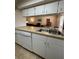 Well-equipped kitchen with stainless steel double sink, dishwasher, and views into the adjacent living area at 1844 Townhall Ln # 1844, Orlando, FL 32807