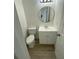 Updated bathroom features a single vanity, round mirror and wood-look flooring at 198 N Lake Ct, Kissimmee, FL 34743