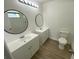 Modern bathroom with double vanities, wood-look flooring, and updated fixtures at 198 N Lake Ct, Kissimmee, FL 34743