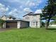 Two story home featuring a well-manicured lawn and complemented by mature trees at 198 N Lake Ct, Kissimmee, FL 34743