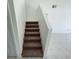 Carpeted stairs lead to an open living area with modern tile flooring at 198 N Lake Ct, Kissimmee, FL 34743