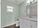 Bright bathroom featuring a white vanity with a stone countertop, light fixtures and a window at 203 Parkwood Ln, Edgewater, FL 32132