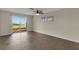 Bright bedroom features hardwood floors, a ceiling fan, and sliding glass doors offering a picturesque backyard view at 203 Parkwood Ln, Edgewater, FL 32132