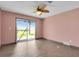 Bedroom with tiled floor, ceiling fan, sliding glass doors to outdoor view with palm trees at 203 Parkwood Ln, Edgewater, FL 32132