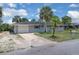 Inviting single-story home featuring an attached garage, well-kept lawn, and mature palms at 203 Parkwood Ln, Edgewater, FL 32132