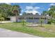 Inviting single-story home featuring a well-manicured lawn, decorative landscaping, and a welcoming entrance at 203 Parkwood Ln, Edgewater, FL 32132