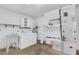 Functional laundry room equipped with a washing machine, dryer, utility sink, shelving, and water heater at 203 Parkwood Ln, Edgewater, FL 32132