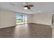 Bright living room featuring sleek hardwood floors and sliding glass doors leading to a backyard view at 203 Parkwood Ln, Edgewater, FL 32132