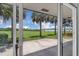 Expansive backyard view through sliding glass doors, showcasing a lush green lawn and waterfront access at 203 Parkwood Ln, Edgewater, FL 32132