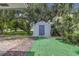 Outdoor storage shed surrounded by lush greenery and trees at 203 Parkwood Ln, Edgewater, FL 32132