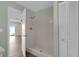 Step-in shower featuring white tile and a shower head in neutral-colored bathroom near wood-look flooring at 203 Parkwood Ln, Edgewater, FL 32132