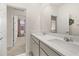 View of bathroom featuring a double vanity, neutral walls, and a view into an adjacent bedroom at 2057 Celebration Blvd, Kissimmee, FL 34747