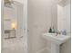 Hallway half bathroom with pedestal sink and a view to a staircase and a hallway at 2057 Celebration Blvd, Kissimmee, FL 34747