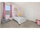 Bright bedroom featuring a single bed with white frame, cozy decor, and a window with pink curtains at 2057 Celebration Blvd, Kissimmee, FL 34747