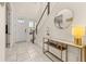 Inviting entryway featuring neutral tones, decorative mirror, console table, and stairway to the upper level at 2057 Celebration Blvd, Kissimmee, FL 34747