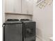 Modern laundry room with gray, front-load Samsung washer and dryer and white cabinets at 2057 Celebration Blvd, Kissimmee, FL 34747