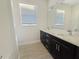 Bathroom featuring dual sinks, dark cabinets, modern fixtures, and wood-look floors at 2164 Crosston Cir, Orlando, FL 32824