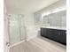 Bright bathroom featuring a glass shower, soaking tub, and double vanity with dark cabinets and light countertops at 2164 Crosston Cir, Orlando, FL 32824